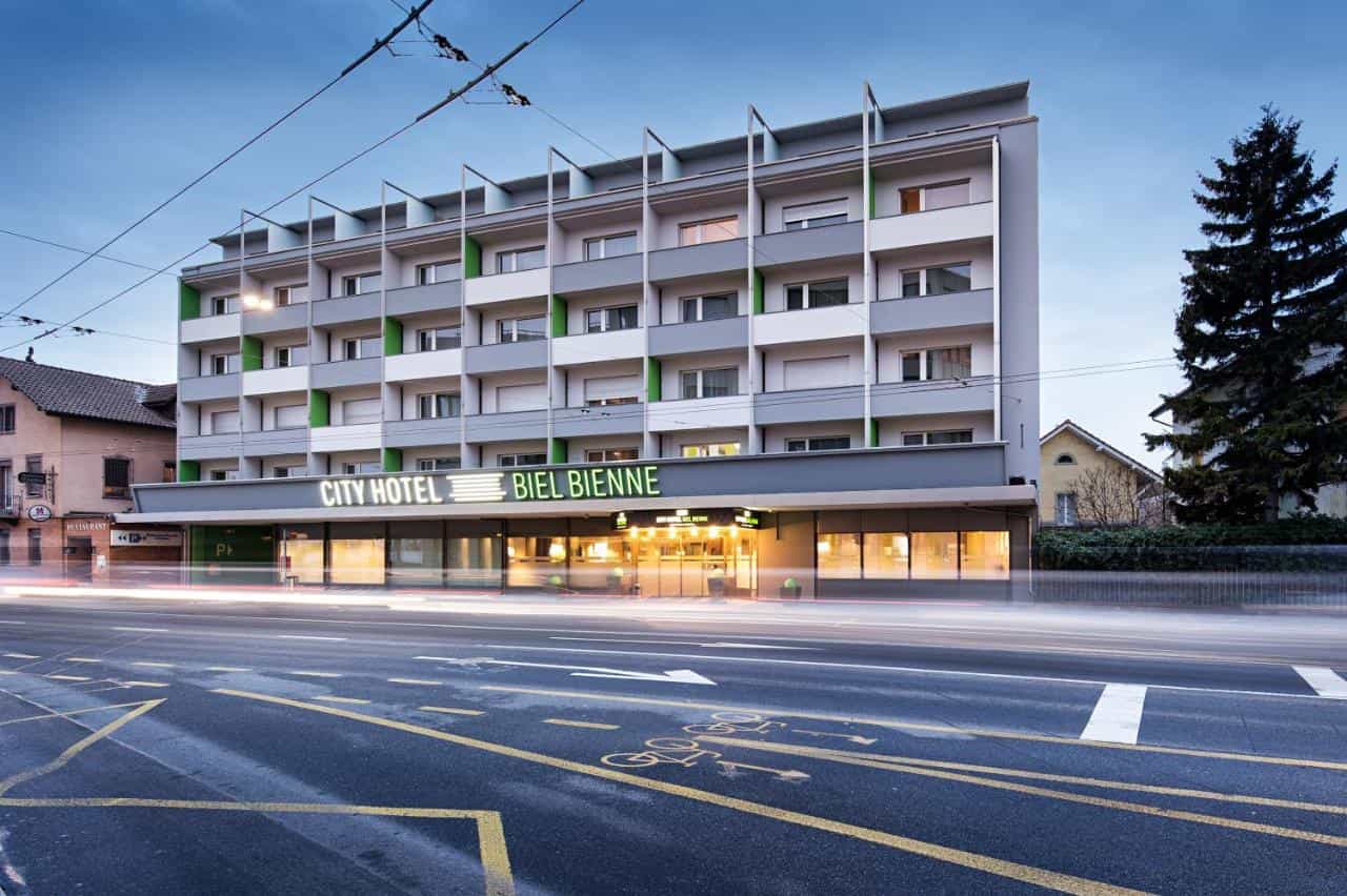 City Hotel Biel Bienne exterior at dusk with light trails from traffic on the street.