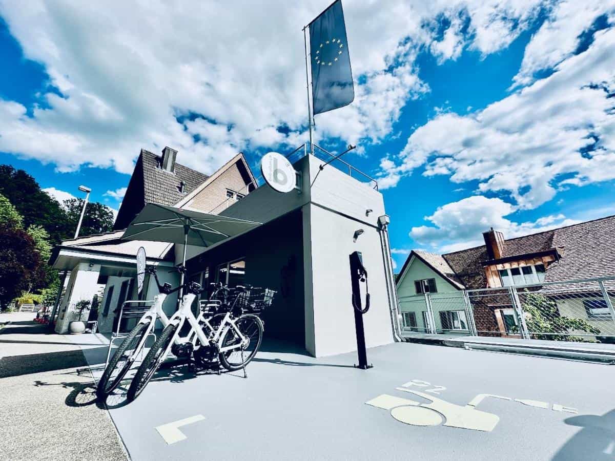 White e-bikes parked outside a building with a European Union flag in Olten.