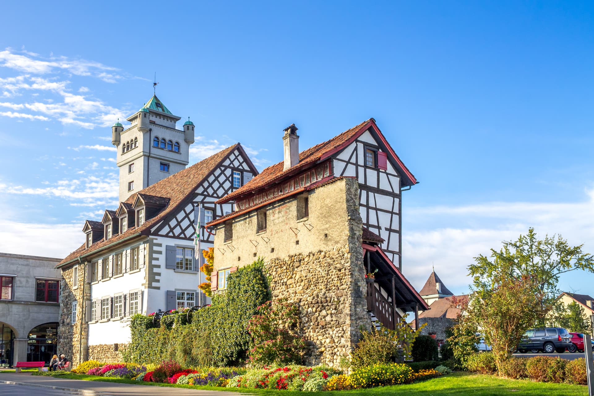 Half-timbered building with stone base and tower under blue sky in Arbon, Kanton Thurgau, Switzerland.