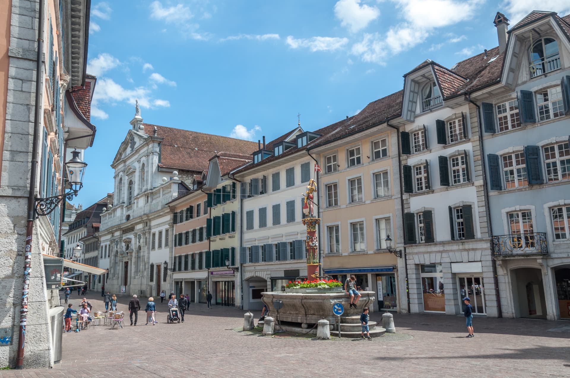 Panorama of Soleure (Solothurn) town square with historic buildings and a central fountain.