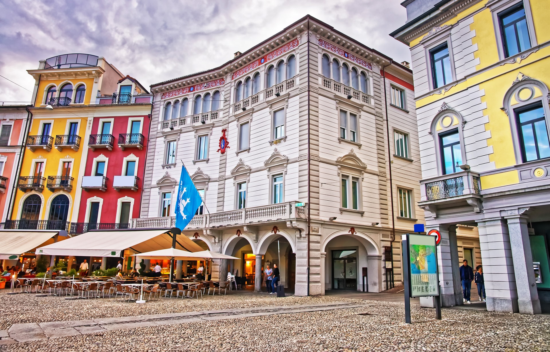 Piazza Grande in Locarno, Ticino, Switzerland, with outdoor cafe seating on cobblestones.