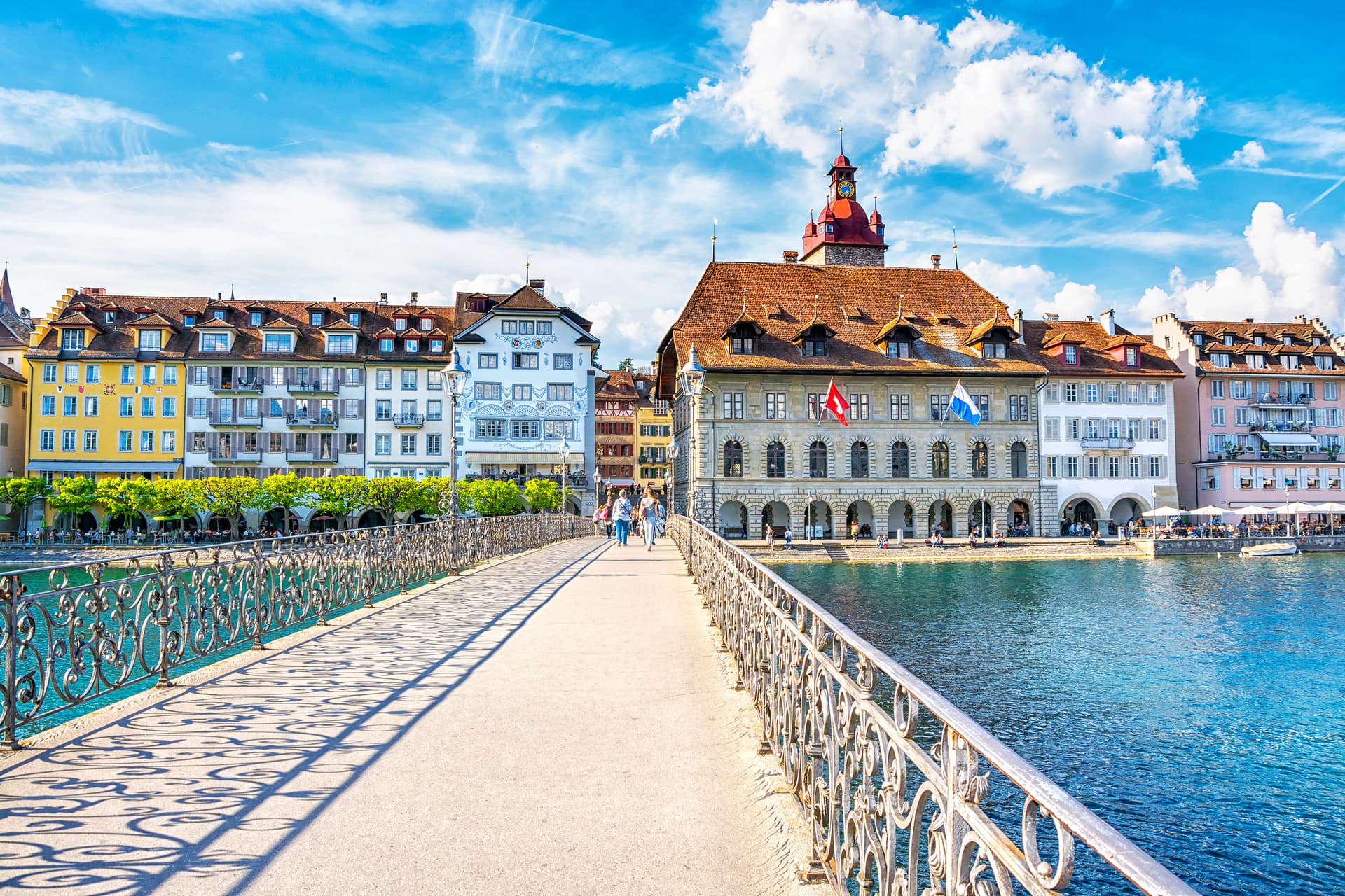 Rathaussteg Bridge over Reuss River with historic buildings and riverside cafes in Lucerne.